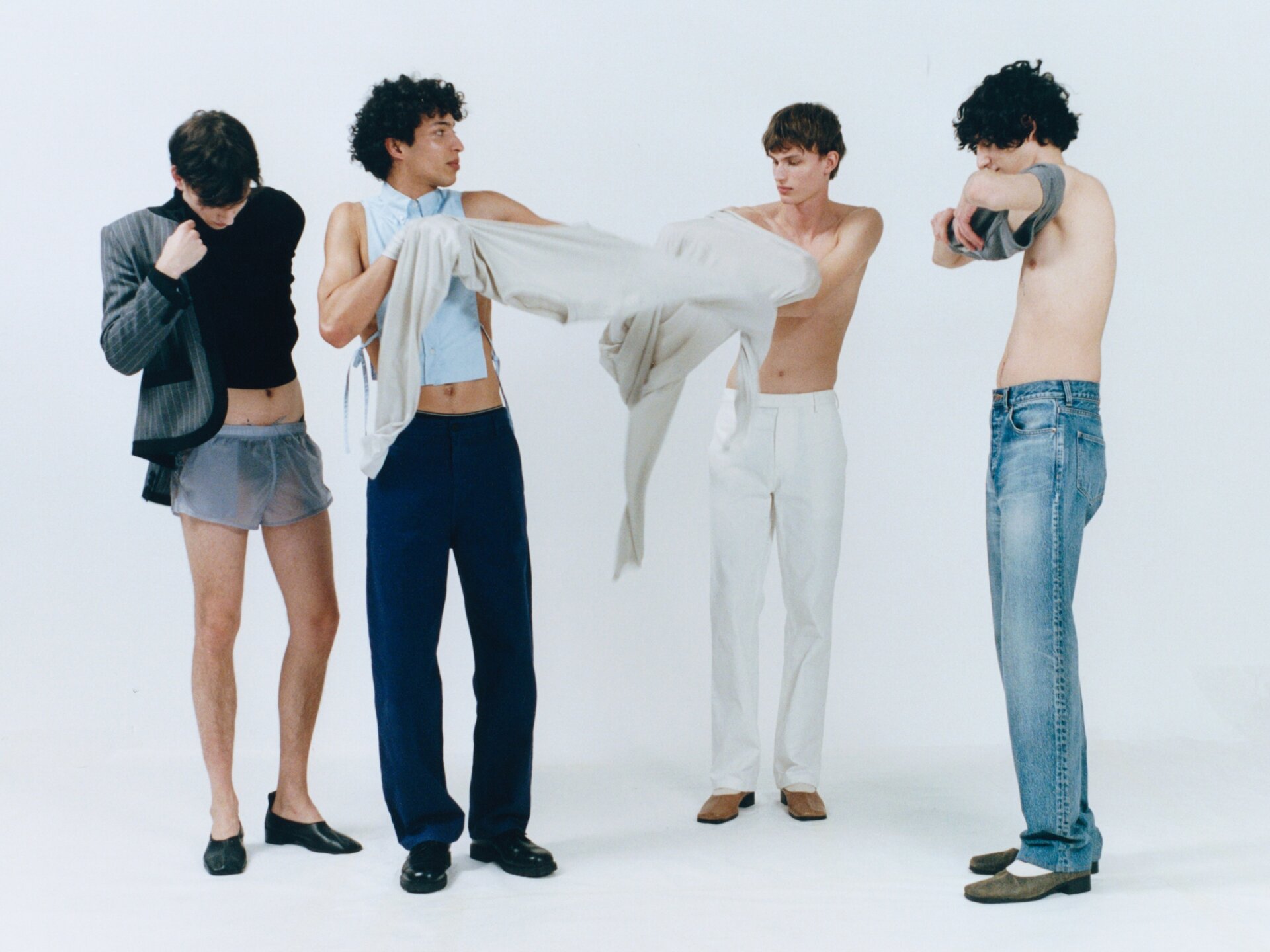 9 Four male models dressing for ACHTUNG 51 behind the scenes shoot